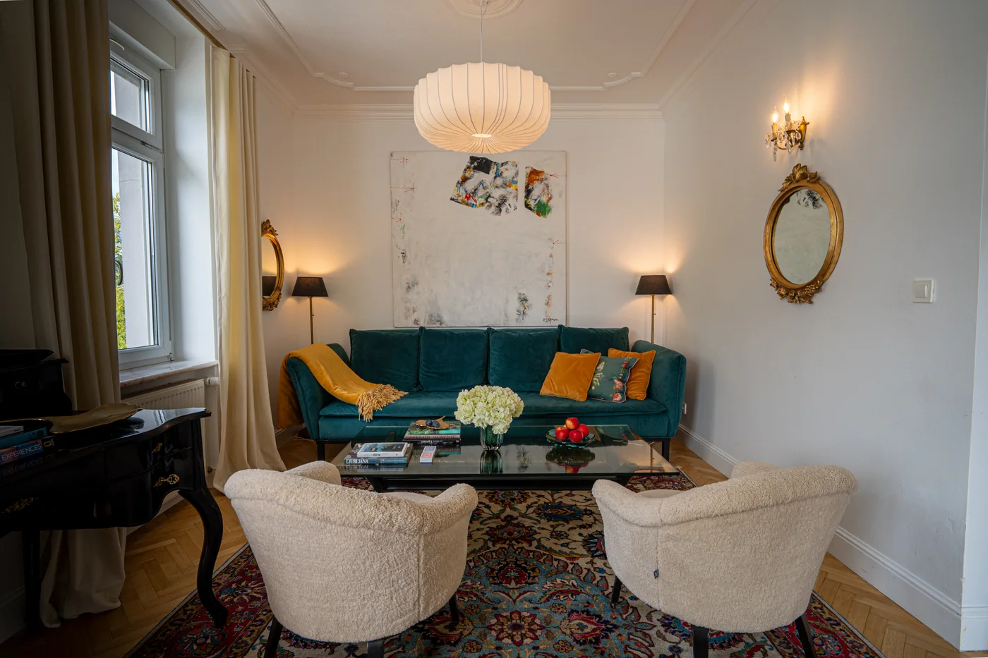 Deluxe Suite living room with a teal sofa and cream armchairs