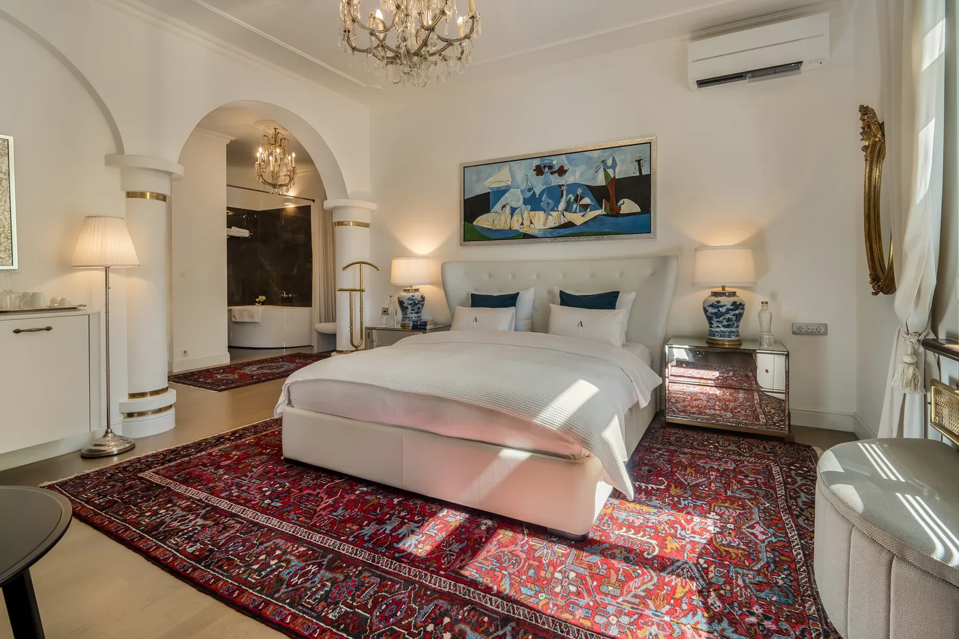 Luxury King Room with a white upholstered bed and an adjoining bathroom